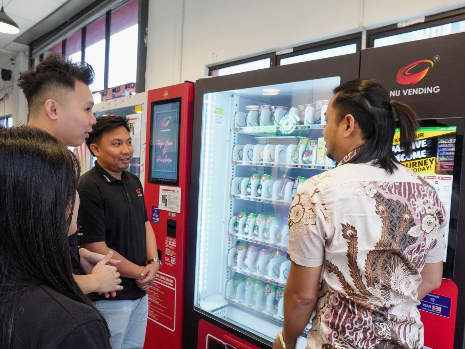 Nu Vending team demonstrating a smart vending machine to a client in the showroom